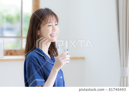 穿著睡衣喝礦泉水的年輕女人 81748493