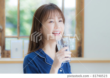 穿著睡衣喝礦泉水的年輕女人 81748523