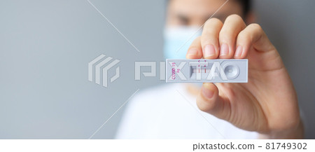 woman holding Rapid Antigen Test kit with Positive result during swab COVID-19 testing. Coronavirus Self nasal or Home test, Lockdown and Home Isolation concept 81749302