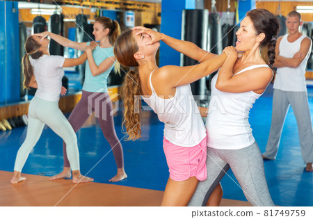 Sporty girls in pairs are training self-defence moves 81749759
