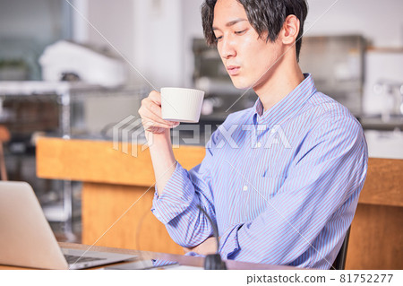 一個年輕人在家工作時喝咖啡提神 一個年輕人在家工作時喝咖啡提神 81752277