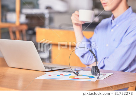 A young man drinking coffee to refresh himself while working remotely 81752278