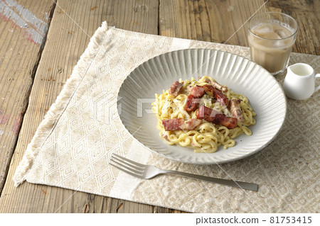 A carbonara pasta lunch with crispy thick-sliced bacon 81753415