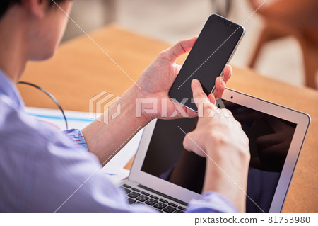 一名年輕人在家工作時注意力不集中並上網 一名年輕人在家工作時注意力不集中並上網 81753980