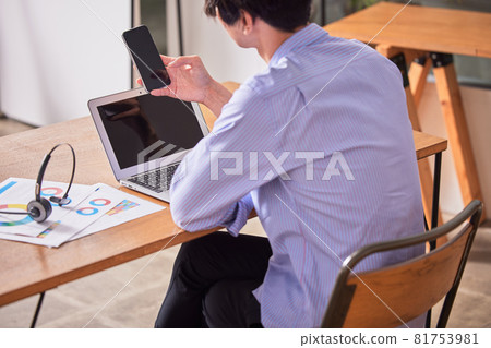 一名年輕人在家工作時注意力不集中並上網 一名年輕人在家工作時注意力不集中並上網 81753981