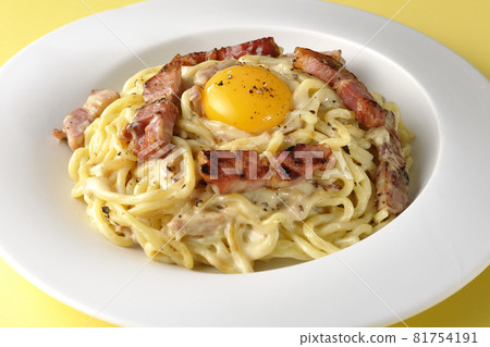 Carbonara with crispy thick-sliced bacon and topped with egg yolk 81754191