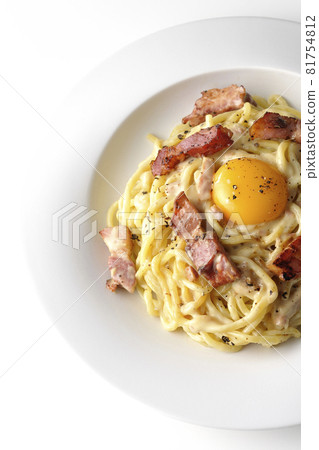 Aerial view of carbonara with egg yolk and crispy thick-sliced bacon on a white background Aerial view of carbonara with egg yolk and crispy thick-sliced bacon on a white background 81754812