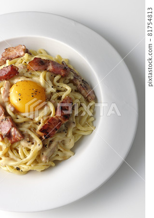 Aerial view of carbonara with egg yolk and crispy thick-sliced bacon on a white background Aerial view of carbonara with egg yolk and crispy thick-sliced bacon on a white background 81754813