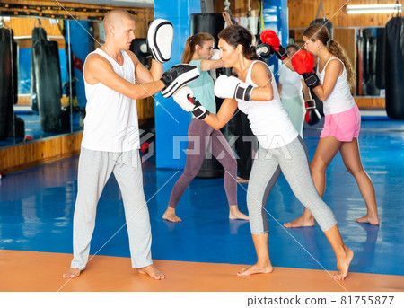Asian woman in boxing gloves during self defense workout Asian woman in boxing gloves during self defense workout 81755877