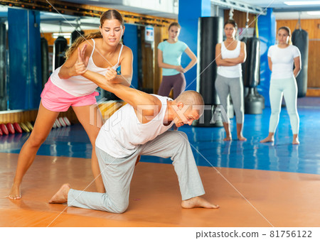Young woman performing armlock Young woman performing armlock 81756122
