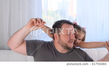 Portrait of smiling dad and daughter, 3 years old, playing at home. Fathers day. Handsome young man 81756860