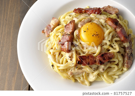 Aerial view of carbonara with egg yolk and crispy thick-sliced bacon 81757527