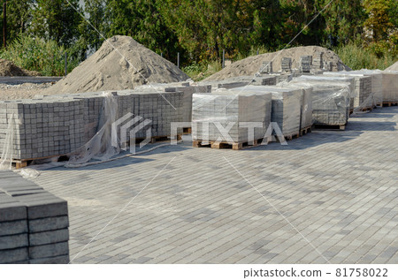 Pallets of gray paving tiles at the construction site. Construction of new sidewalks and roads. Industry. Pallets of gray paving tiles at the construction site. Construction of new sidewalks and roads. Industry. 81758022