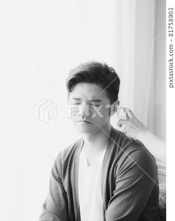 Young Asian man wearing surgical mask and using ear thermometer to measure body temperature 81758901