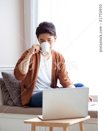 Asian young man sitting in front of laptop Asian young man sitting in front of laptop 81758950