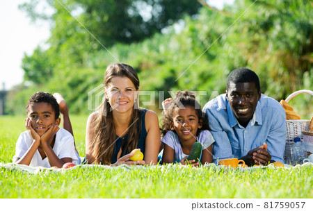 Couple with children lying on green lawn 81759057