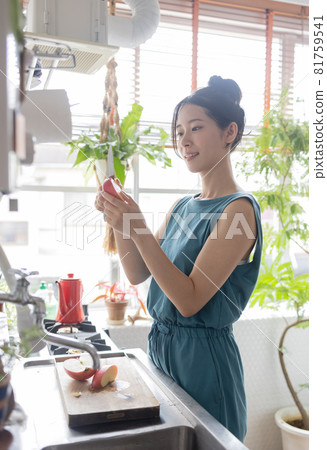 Young woman cutting an apple in the kitchen Young woman cutting an apple in the kitchen 81759541