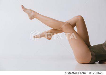 Beautiful slender female legs isolated over gray background. Anti-cellulite care 81760626