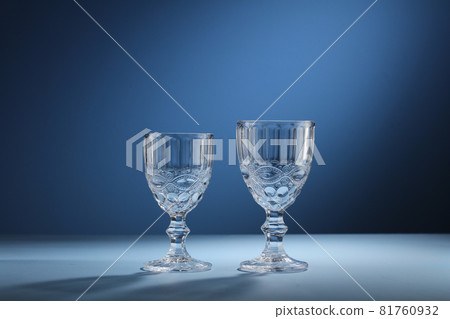 Different empty glasses on blue background 81760932