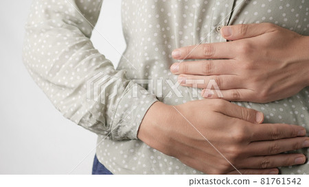 Stomach pain. Female hands restlessly touching belly on white background. Close-up 81761542