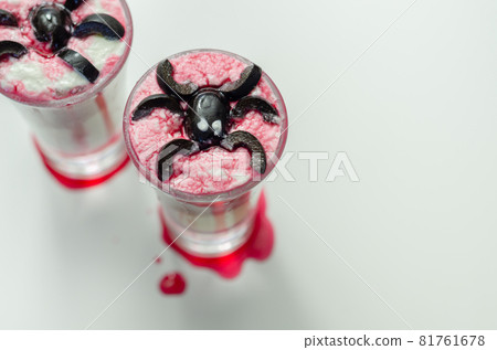 Drinks shots prepared by the bartender at the Halloween party decorated with black olives in the shape of spiders Drinks shots prepared by the bartender at the Halloween party decorated with black olives in the shape of spiders 81761678