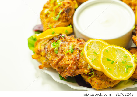 Delicious onion bhaji fritters served on ceramic plate with white dip Delicious onion bhaji fritters served on ceramic plate with white dip 81762243