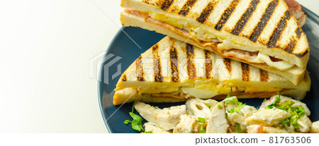 White bread with beechwood smoked bacon, egg, mayonnaise, and tomato served with Caesar pasta with parmesan cheese on the blue plate 81763506