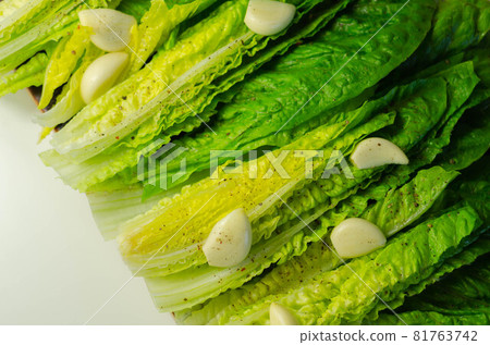 Fresh, cut romaine lettuce with garlic, pepper and salt Fresh, cut romaine lettuce with garlic, pepper and salt 81763742