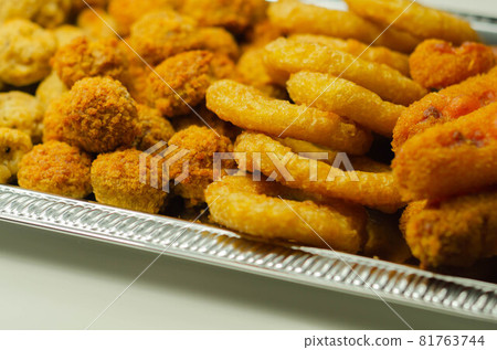 Southern fried and roast chicken bites, onion rings and mozzarella stick served on the silver tray Southern fried and roast chicken bites, onion rings and mozzarella stick served on the silver tray 81763744