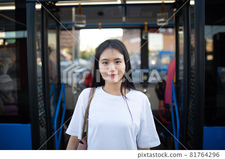 Asian Woman get out through doors after ride in public transport bus or tram. Asian Woman get out through doors after ride in public transport bus or tram. 81764296