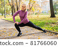Young woman does stretching exercises in the park. Sports outside in autumn 81766060
