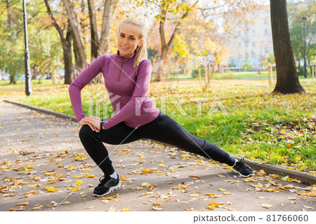 Young woman does stretching exercises in the park. Sports outside in autumn Young woman does stretching exercises in the park. Sports outside in autumn 81766060