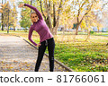 Young woman does exercises in the park. Sports outside in autumn 81766061