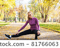 Young woman does stretching exercises in the park. Sports outside in autumn 81766063