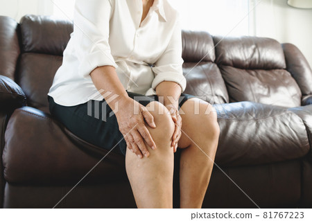 senior woman suffering from knee pain at home, health problem concept 81767223