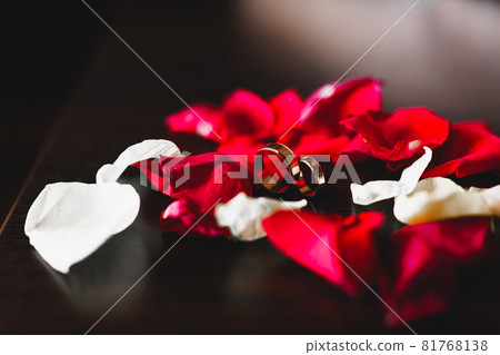 Beautiful toned picture with wedding rings against the background of a bouquet of flowers Beautiful toned picture with wedding rings against the background of a bouquet of flowers 81768138