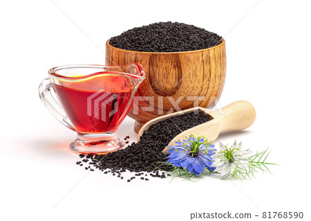 Black cumin oil in gravy boat and nigella sativa flowers. Nigella sativa seeds in wooden scoop isolated on white background. Black cumin oil in gravy boat and nigella sativa flowers. Nigella sativa seeds in wooden scoop isolated on white background. 81768590