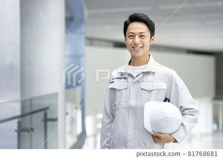 一個穿著工作服的男人看著相機微笑的肖像 81768681