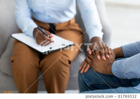 Unrecognizable psychotherapist supporting depressed male patient, touching his hands at medical office, closeup 81769332