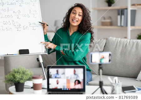 Math teacher showing board, giving virtual lecture to students Math teacher showing board, giving virtual lecture to students 81769389