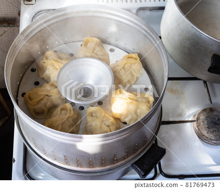 homemade manti are cooking in aluminum steamer on stove in home kitchen 81769473