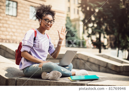 Black Student Girl With Laptop Waving Hand Sitting Outside 81769946