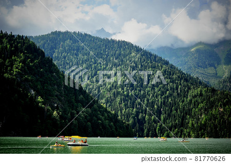Catamarans on Lake Ritsa in Abkhazia. Walks on the water. Ecologically clean place in the mountains. 81770626