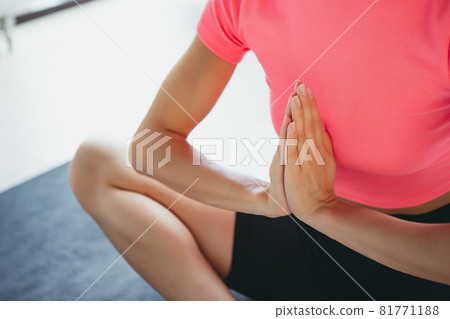 Cropped image of young slim sportive woman in sportswear doing yoga exercise on sports mat at yoga meditation center. Concept of healthy lifestyle, wellbeing, mental health 81771188