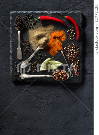 Chili and black pepper on black background Chili and black pepper on black background 81772126