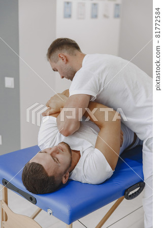 Male physiotherapist massaging man's back 81772584