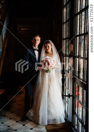 bride and groom in the sunlight at the glass door. beautiful and happy wedding.  81772639