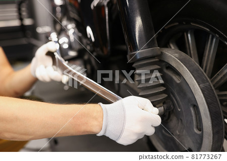 Mechanic hand use wrench and nozzle to adjust motorcycle shock absorber Mechanic hand use wrench and nozzle to adjust motorcycle shock absorber 81773267