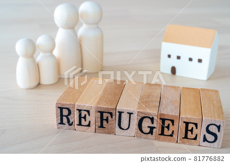 Refugees | Wooden stamp with the word "REFUGEES" written on it, dolls, and house toys 81776882