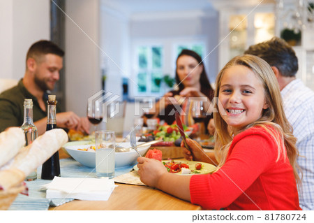 Portrait of caucasian grandfather and parents with daughter sitting at table having dinner 81780724